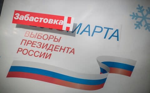A Navalny sticker reading "boycott" blocks out the the date on a poster advertising the presidential election in Veliky Novgorod - Credit: Dmitri Beliakov/For The Telegraph