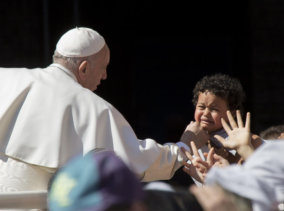 Pope Francis caresses a child as he leaves the Basilica of Our Lady of Loreto where he celebrated mass and prayed in the shrine containing a small house traditionally venerated as the house of Mary, and believed miraculously transplanted from the Holy Land inside the Basilica, in central Italy, during a one-day visit, Monday, March 25, 2019. The pope chose Loreto to sign the Post-Synodal Exhortation of last October's Synod of Bishops. (AP Photo/Domenico Stinellis)