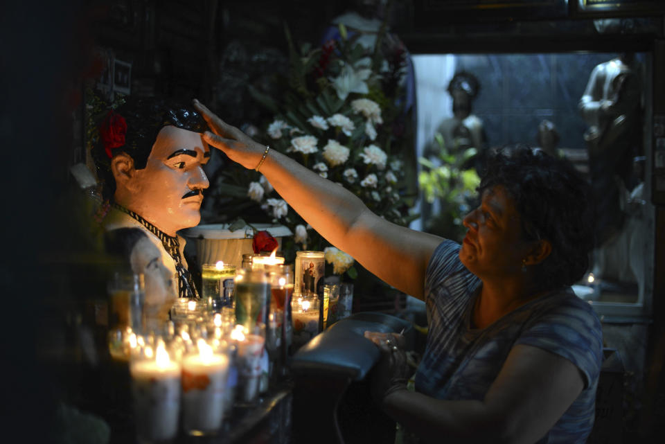 FILE - In this July 20, 2015 file photo, Guadalupe Tadeo de Valenzuela prays to folk-saint Jesus Malverde, to heal her sick daughter in the saint's chapel in Culiacan, Mexico. Jesus Malverde is also worshipped by many drug traffickers in this region which is also known as the the cradle of drug trafficking in the country. (AP Photo/Fernando Brito, File)