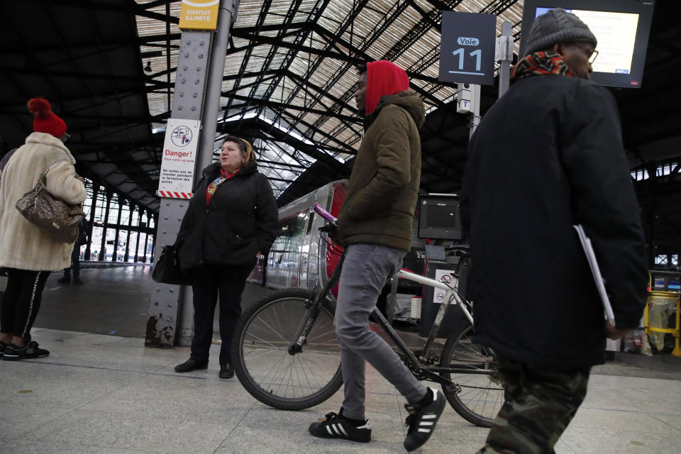 Commuters walk to get on a train at the Gare Saint Lazare station in Paris, France, Monday, Dec. 16, 2019. French transport strikes against a planned overhaul of the pension system entered their twelfth day Monday as French president Emmanuel Macron's government remains determined to push ahead with its plans. (AP Photo/Francois Mori)