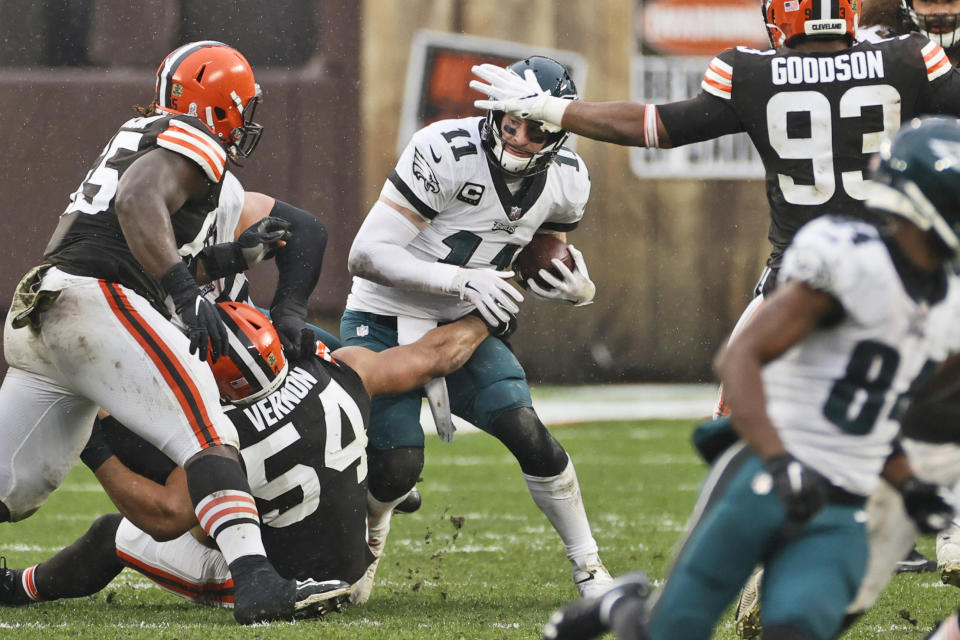 Philadelphia Eagles quarterback Carson Wentz (11) is sacked by Cleveland Browns defensive end Olivier Vernon (54) during the second half of an NFL football game, Sunday, Nov. 22, 2020, in Cleveland. (AP Photo/Ron Schwane)