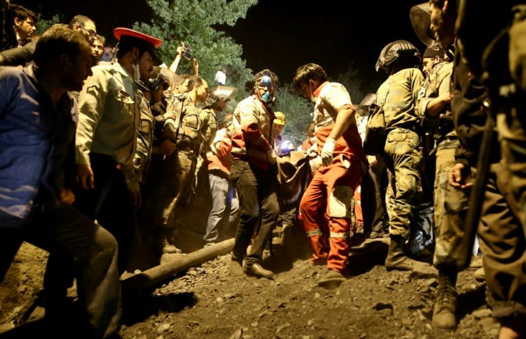 Rescue workers carry the body of a coal miner pulled out of a mine at Azadshahr, in northern Iran, on May 4, 2017