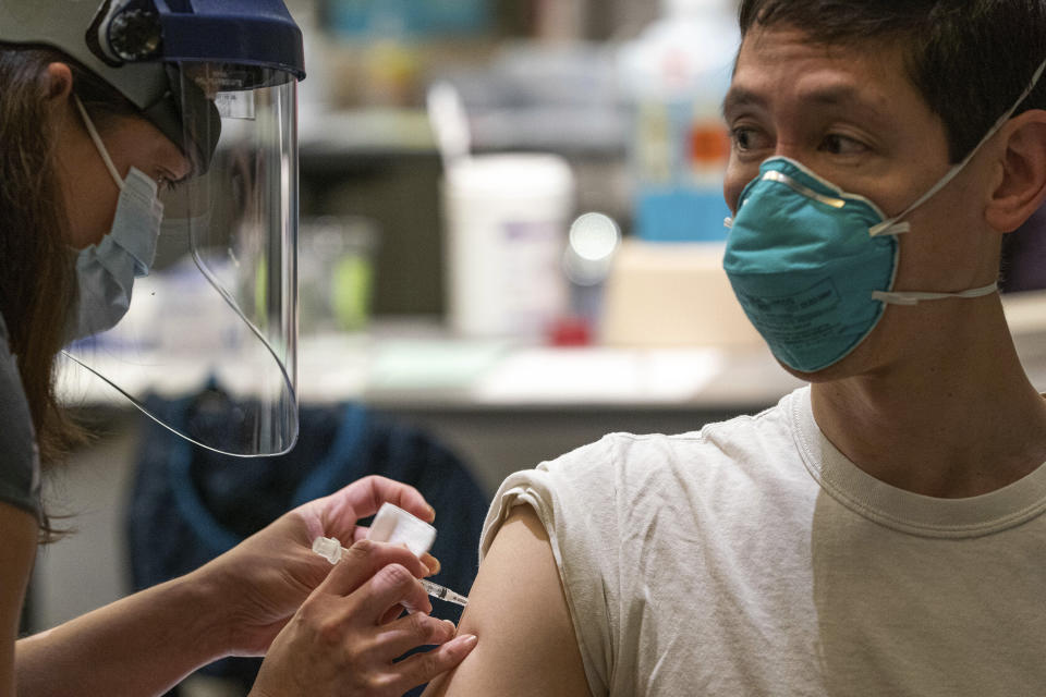 Plastic surgeon Daniel Suver receives the Pfizer-BioNtech COVID-19 vaccine from Andrea Castelblanco during a vaccine clinic on Wednesday, Dec. 16, 2020, at Providence Alaska Medical Center in Anchorage, Alaska. The hospital, Alaska's largest, plans to vaccinate 485 people this week.(Loren Holmes/Anchorage Daily News via AP, Pool)