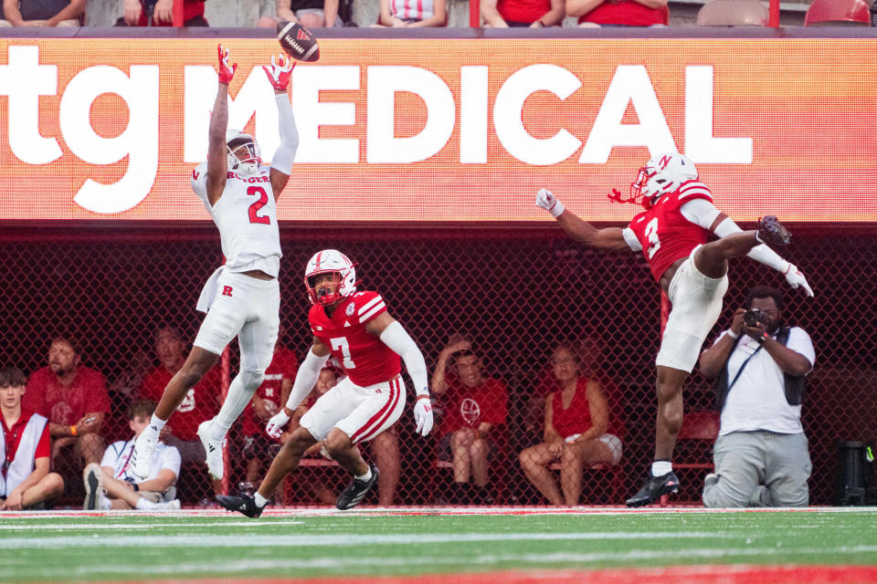 Oct 5, 2024; Lincoln, Nebraska, USA; Rutgers Scarlet Knights wide receiver Ben Black (2) catches a pass for a touchdown against Nebraska Cornhuskers defensive back Malcolm Hartzog Jr. (7) and defensive back Marques Buford Jr. (3) during the fourth quarter at Memorial Stadium. Mandatory Credit: Dylan Widger-Imagn Images