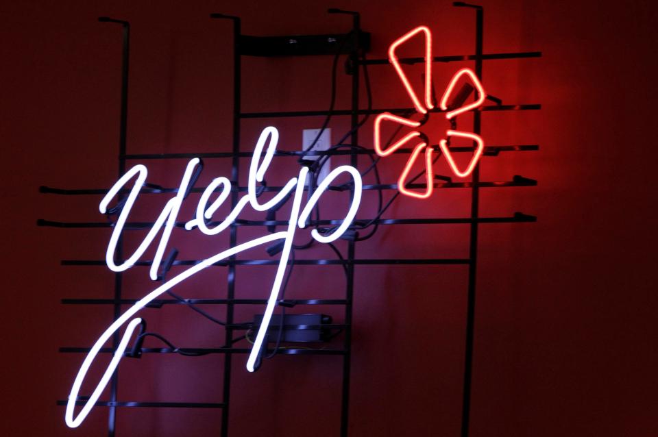 In this Oct. 26, 2011, file photo, the logo of the online reviews website Yelp is shown in neon on a wall at the company's Manhattan offices in New York. Yelp is closing some physical offices, saying employees were hardly using them since the company went remote. Yelp said Thursday, June 23, 2022, it's closing offices in New York, Washington and Chicago and downsizing in Phoenix.