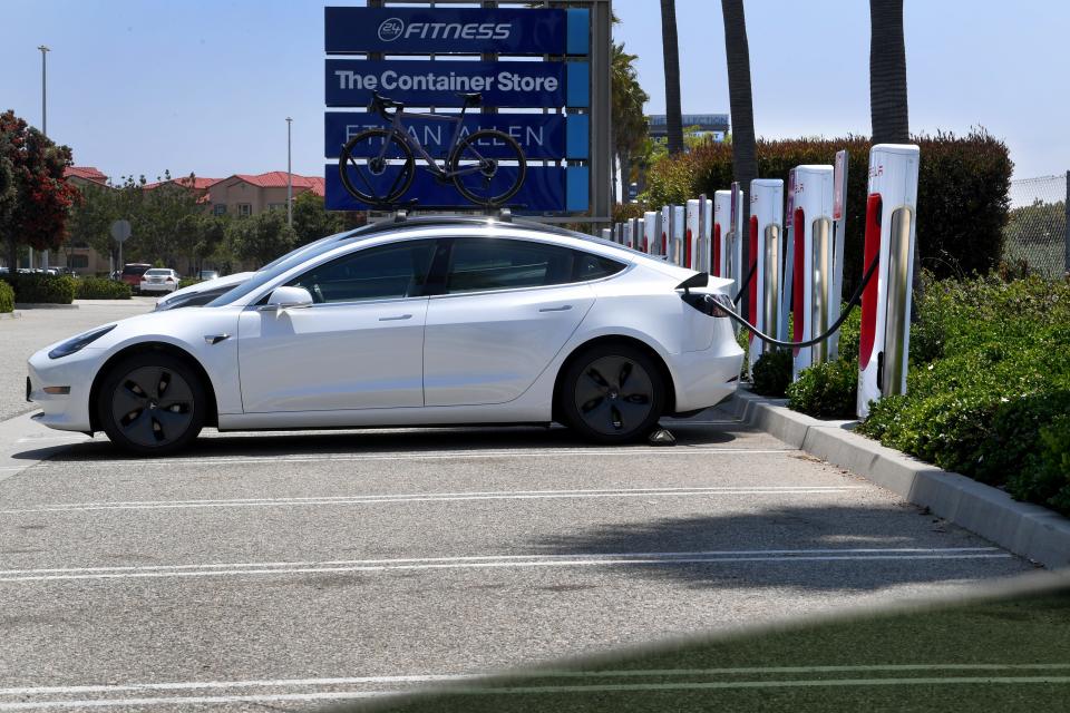 A Tesla plugs into an electric vehicle charging station in Oxnard.