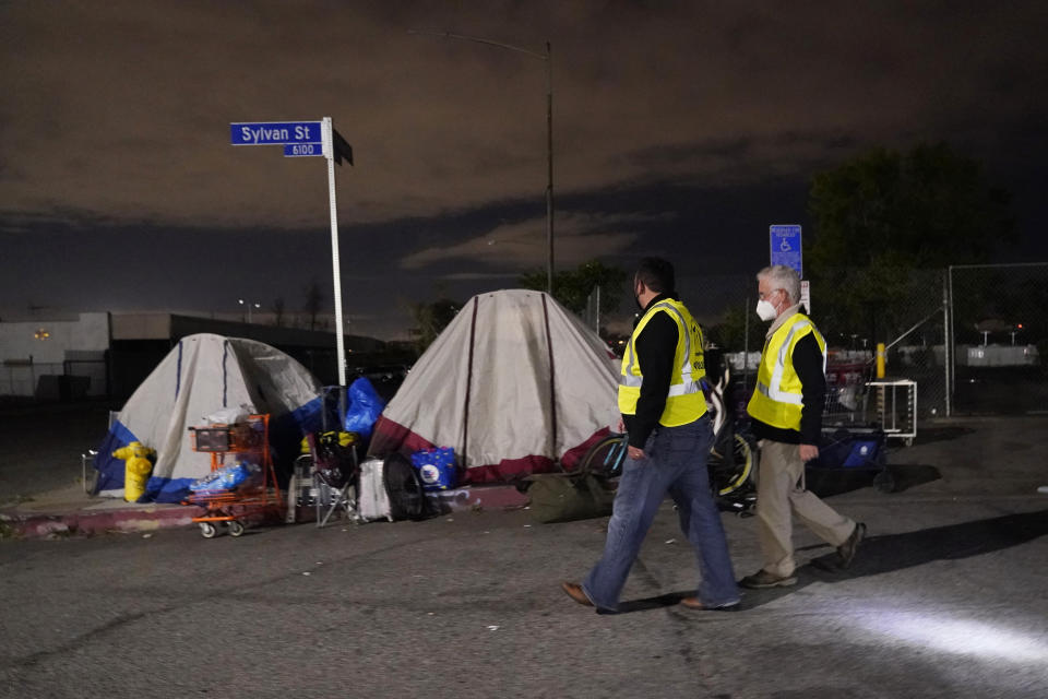 Los Angeles city councilmember Paul Krekorian, right, walks past tents where people are living as he walks with staff member Karo Torossian during an official homeless count Tuesday, Feb. 22, 2022, in the North Hollywood section of Los Angeles. Los Angeles County has resumed its annual homeless count in full a year after it was limited over concerns that it couldn't be done safely or accurately during the coronavirus pandemic. (AP Photo/Marcio Jose Sanchez)