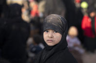 A girl waits to be screened by U.S.-backed Syrian Democratic Forces (SDF) female fighters after being evacuated out of the last territory held by Islamic State militants, near Baghouz, eastern Syria, Friday, Feb. 22, 2019. (AP Photo/Felipe Dana)