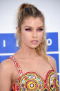 <p>Her ring-around-the-eyes makeup in dark pink enhances her light-colored eyes and is set off by a ponytail and lips just a few shades away from nude. (Photo: Getty Images)</p>