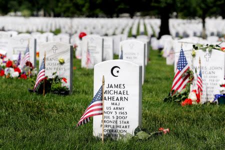 A U.S. flag stands next to the grave marker of U.S. Army Major James Michael Ahearn inside of Section 60 in Arlington National Cemetery on Memorial Day, May 30, 2016. REUTERS/Lucas Jackson