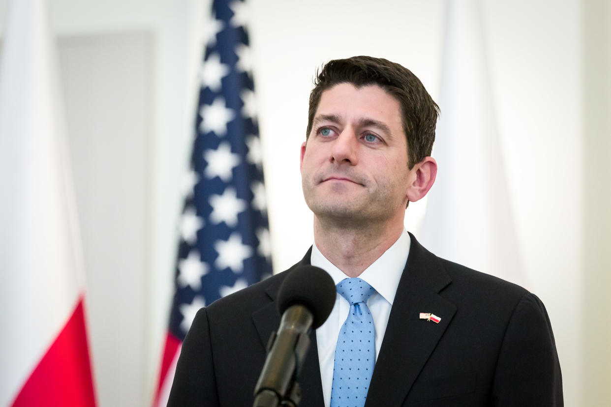 Paul Ryan at a microphone with a U.S. flag behind him.