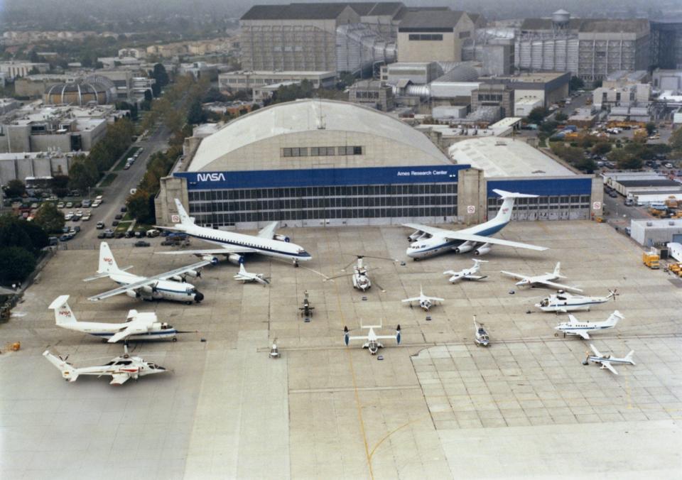 A stunning photo of the varied Ames test aircraft on the ramp in 1986. Visible are the DC-8, C-130, QSRA, Sikorsky Rotor Systems Research Aircraft (RSRA), C-141, U-2, SH-3G, King Air, YO-3A, T-38, CH-47, Learjet, AH-1G, AV-8B, OH-58A, XV-15, and UH-1H. <em>Ron Allen</em>