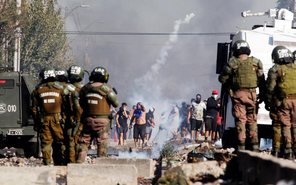 People clash with police during a protest for lack of food - SEBASTIAN SILVA/EPA-EFE/Shutterstock