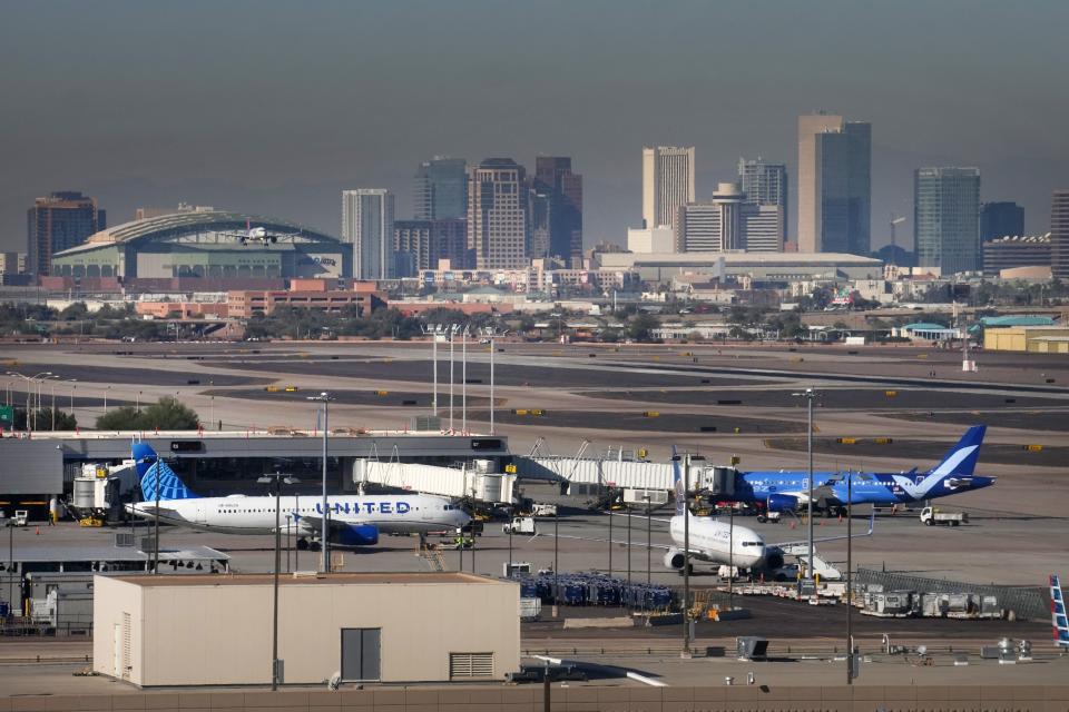 Airplanes land with a view of Downtown Phoenix at Sky Harbor International Airport on Wednesday, Dec. 21, 2022. 