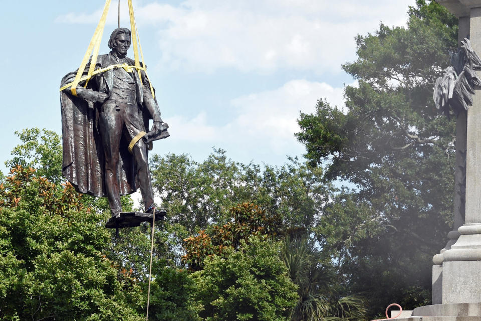 FILE - A statue of former U.S. vice president and slavery advocate John C. Calhoun is raised by crews after its removal, June 24, 2020, in Charleston, S.C. The statue still hasn't found a new home and a lawsuit says it was illegally removed and should be put back up. Charleston leaders and officials at South Carolina’s State Museum announced Monday, Feb. 7, 2022 they have started talking about a deal bringing the statue to the museum's Columbia site, but there are plenty of details to hammer out and Charleston City Council must agree to a long-term loan of the bronze figure of the staunch advocate for slavery. (AP Photo/Meg Kinnard, file)