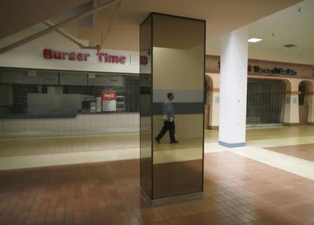 A man walks past empty stores in the deserted Carousel shopping mall in San Bernardino, California September 11, 2012. REUTERS/Lucy Nicholson