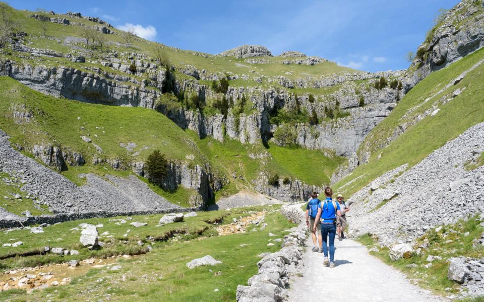 Walkers on their way to Gordale Scar, a limestone ravine near Malham, North Yorkshire, England