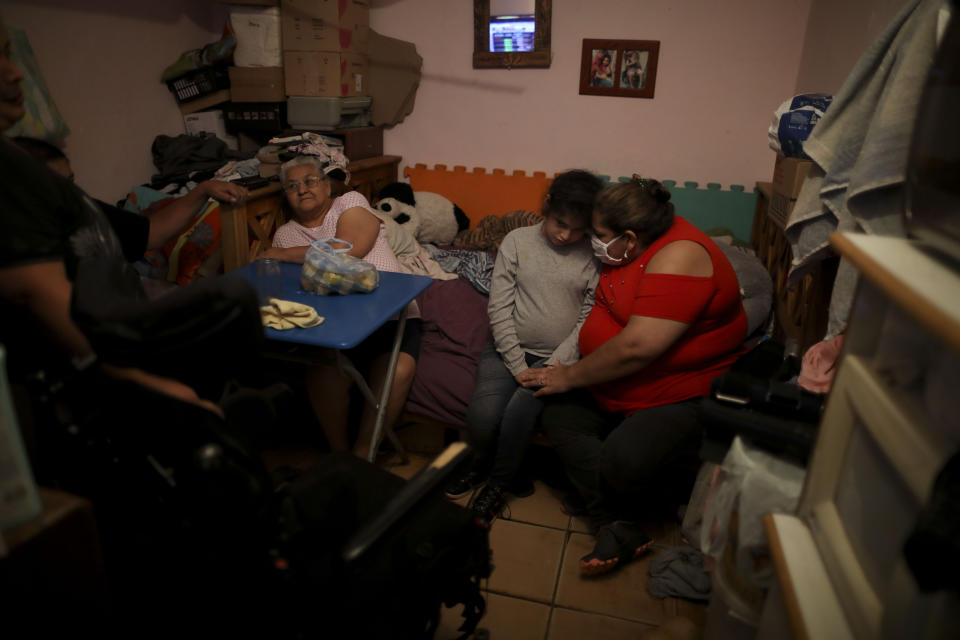 Ramona Medina, right, embraces her daughter Guadalupe, in the room they share with three other people at the Villa 31 slum during a government-ordered shutdown as a measure to help curb the spread of the new coronavirus, in Buenos Aires, Argentina, Friday, May 1, 2020. "The virus is killing all of us here," Medina said in an interview with The Associated Press in early May. She died from the virus two weeks later. (AP Photo/Natacha Pisarenko)