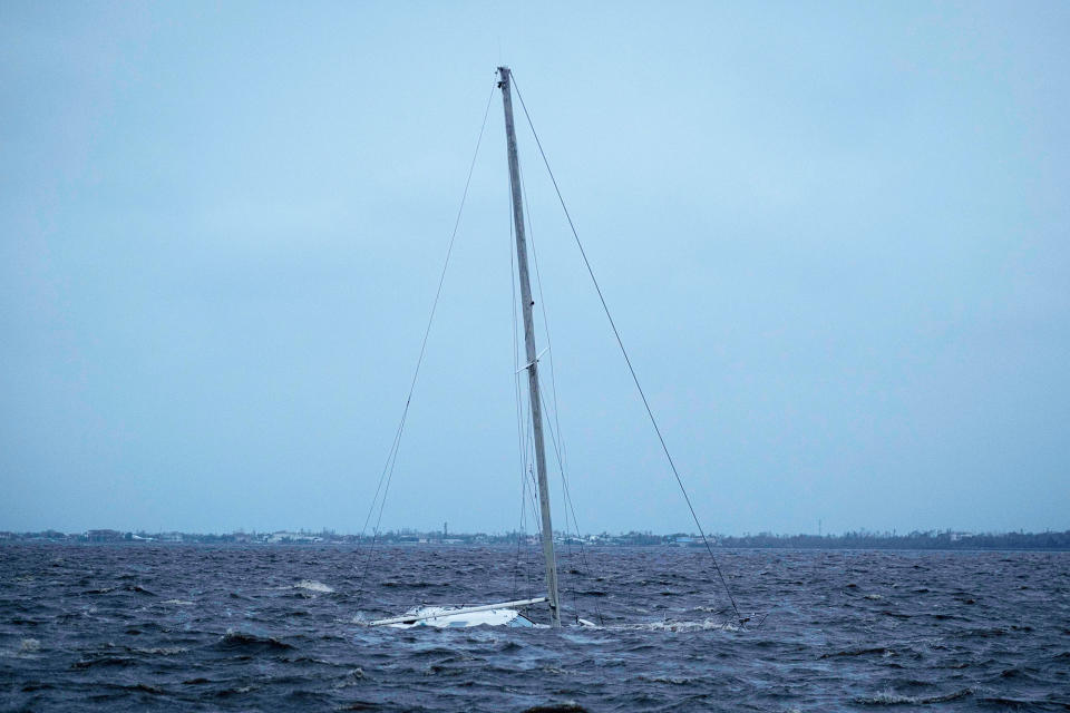 A sailboat lies partially submerged in the waters off Punta Gorda, Florida, on Sept. 29, 2022.