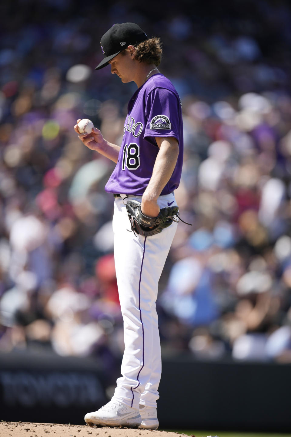 Colorado Rockies starting pitcher Ryan Feltner studies a new ball after giving up a three-run home run to Atlanta Braves' Adam Duvall in the third inning of a baseball game Sunday, Sept. 5, 2021, in Denver. (AP Photo/David Zalubowski)