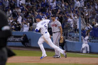 Los Angeles Dodgers' Freddie Freeman, left, rounds second after hitting a solo home run as Atlanta Braves first baseman Matt Olson watches during the first inning of a baseball game Monday, April 18, 2022, in Los Angeles. (AP Photo/Mark J. Terrill)