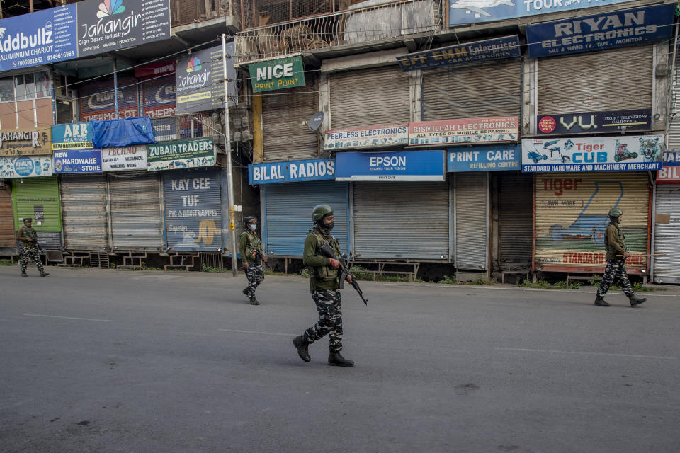 Indian paramilitary soldiers patrol a deserted street on the first anniversary of India’s decision to revoke the disputed region’s semi-autonomy, in Srinagar, Indian controlled Kashmir, Wednesday, Aug. 5, 2020. Last year on Aug. 5, India’s Hindu-nationalist-led government of Prime Minister Narendra Modi stripped Jammu-Kashmir of its statehood and divided it into two federally governed territories. Late Tuesday, authorities lifted a curfew in Srinagar but said restrictions on public movement, transport and commercial activities would continue because of the coronavirus pandemic. (AP Photo/ Dar Yasin)