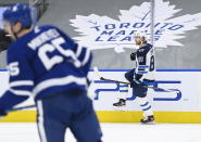 Winnipeg Jets left wing Kyle Connor (81) celebrate his goal as Toronto Maple Leafs right wing Ilya Mikheyev (65) skates by during second period NHL hockey action in Toronto on Monday, Jan. 18, 2021. (Nathan Denette/The Canadian Press via AP)