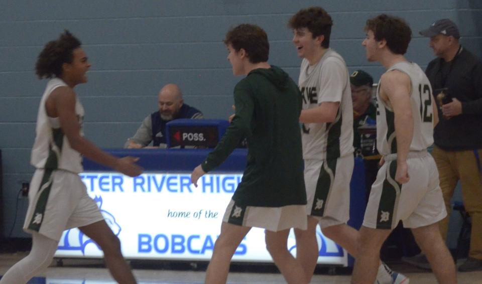 Members of the Dover High School boys basketball team come off the bench to congratulate freshman Amari Lewis on his game-winning shot in the final seconds of Thursday's Oyster River Holiday Classic championship game. Dover captured its second holiday title in three years with a 58-56 win.