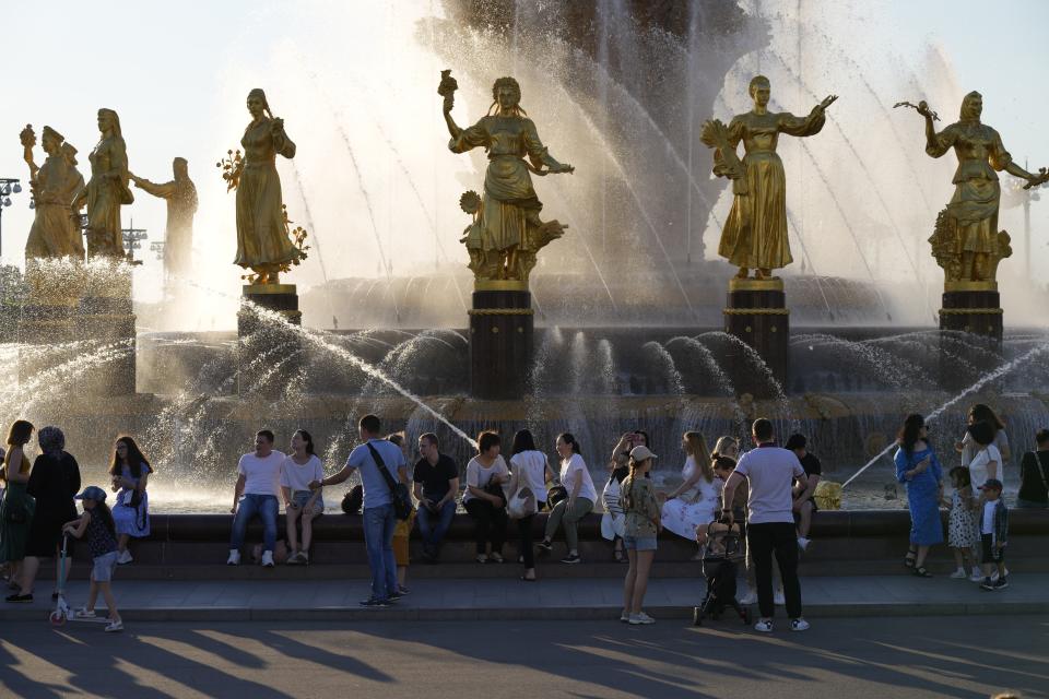 People cool themselves at a fountain "Friendship of Peoples" at VDNKh (The Exhibition of Achievements of National Economy) in Moscow, Russia, Sunday, June 20, 2021. The hot weather in Moscow is continuing, with temperatures forecast to reach over 30 degrees Celsius (86 Fahrenheit). (AP Photo/Alexander Zemlianichenko)