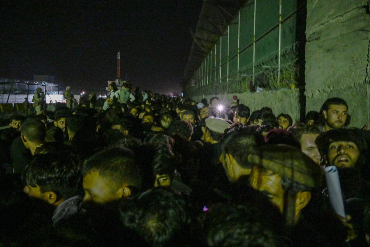 In this picture taken in the late hours on August 22, 2021 Afghans wait outside the foreign military-controlled part of the airport in Kabul, hoping to flee the country following the Taliban's military takeover of Afghanistan. (Photo by WAKIL KOHSAR / AFP) (Photo by WAKIL KOHSAR/AFP via Getty Images)