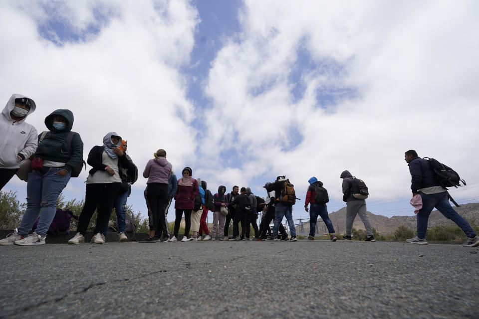 A group of migrants line up as they wait to apply for asylum after crossing the border, Wednesday, May 10, 2023, near Jacumba, Calif. The group have been camping just across the border for days, waiting to apply for asylum in the United States. The Biden administration on Thursday will begin denying asylum to migrants who arrive at the U.S.-Mexico border without first applying online or seeking protection in a country they passed through, marking a fundamental shift in immigration policy as the U.S. readies for the end of a key pandemic restriction. (AP Photo/Gregory Bull)