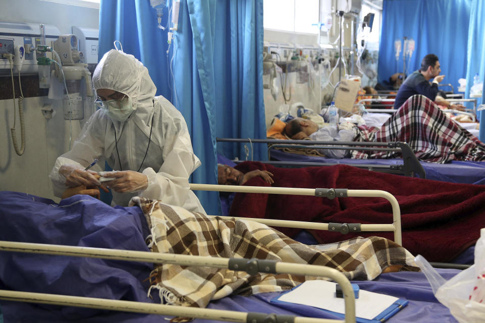 A medic treats a patient infected with the new coronavirus, at a hospital in Tehran, Iran, Sunday, March 8, 2020. With the approaching Persian New Year, known as Nowruz, officials kept up pressure on people not to travel and to stay home. Health Ministry spokesman Kianoush Jahanpour, who gave Iran's new casualty figures Sunday, reiterated that people should not even attend funerals. (AP Photo/Mohammad Ghadamali)