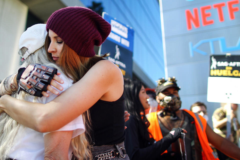 LOS ANGELES, CALIFORNIA - NOVEMBER 08: Picketers embrace as SAG-AFTRA members and supporters picket outside Netflix studios on day 118 of their strike against the Hollywood studios on November 8, 2023 in Los Angeles, California. A tentative labor agreement has been reached between the actors union and the Alliance of Motion Picture and Television Producers (AMPTP) with the strike set to end after midnight. (Photo by Mario Tama/Getty Images)