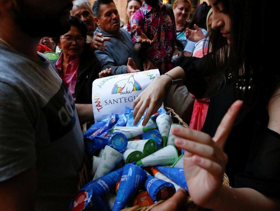 Charity workers distribute ice creams to guests at a community centre in Rome (Reuters)