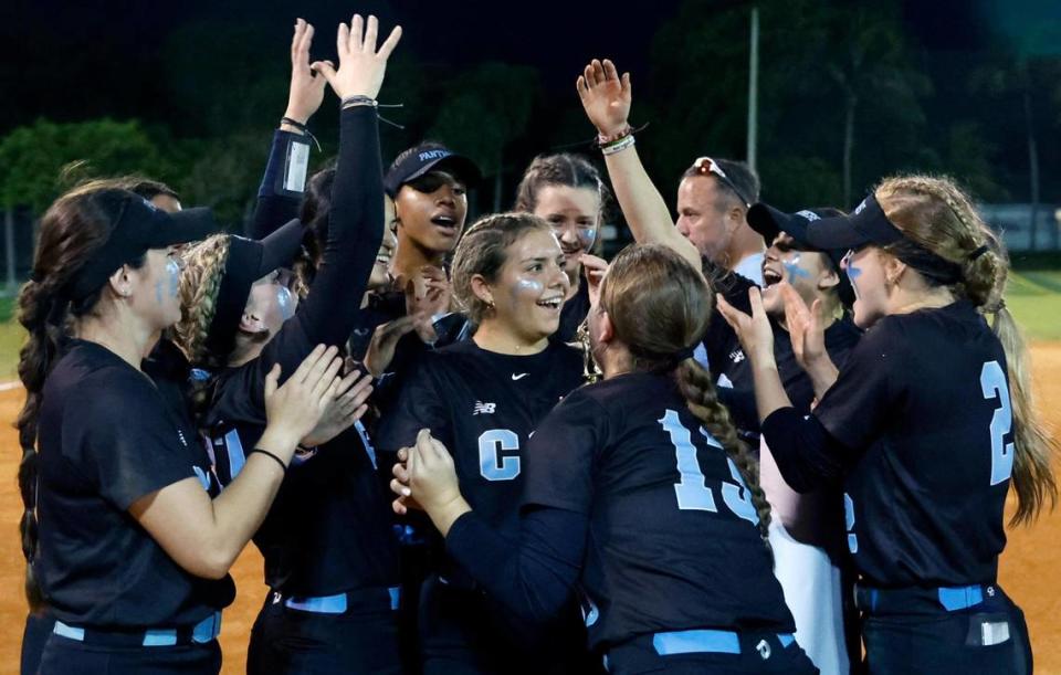 Coral Springs Charter teammates celebrate with Stephanie Basso (22), at center, after she receives the game MVP award after the team defeats Western in the BCAA Big 8 softball championship game at Pompano Beach Community Park in Pompano Beach on Thursday, April 27, 2023.