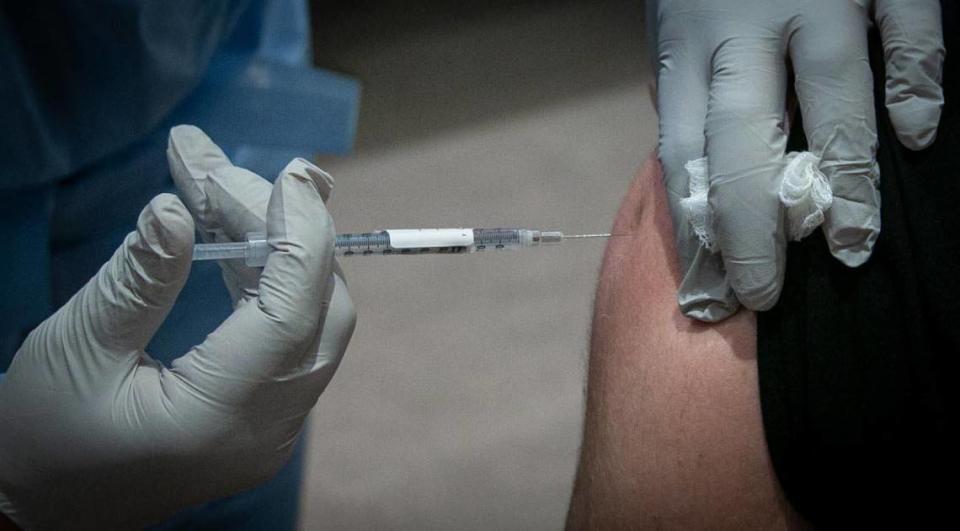 David Lindsey, an ICU nurse at Baptist Hospital, gets his vaccine Wednesday morning as Baptist Health began administering the first COVID-19 vaccines for its front-line healthcare workers in Miami, Florida, on Dec. 16, 2020.