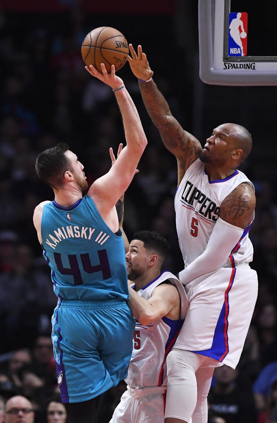 Charlotte Hornets center Frank Kaminsky III, left, shoots as Los Angeles Clippers guard Austin Rivers, center, and center Marreese Speights defend during the first half of an NBA basketball game, Sunday, Feb. 26, 2017, in Los Angeles. (AP Photo/Mark J. Terrill)