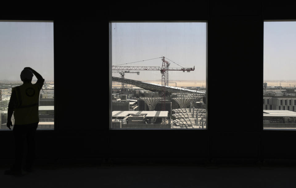 In this Oct. 8, 2019, photo, a visitor looks at the Sustainability Pavilion of the under construction site of the Expo 2020 in Dubai, United Arab Emirates. Dubai is betting billions of dollars that its Expo 2020 will draw 25 million visitors, encourage business and spur development of the city. (AP Photo/Kamran Jebreili)