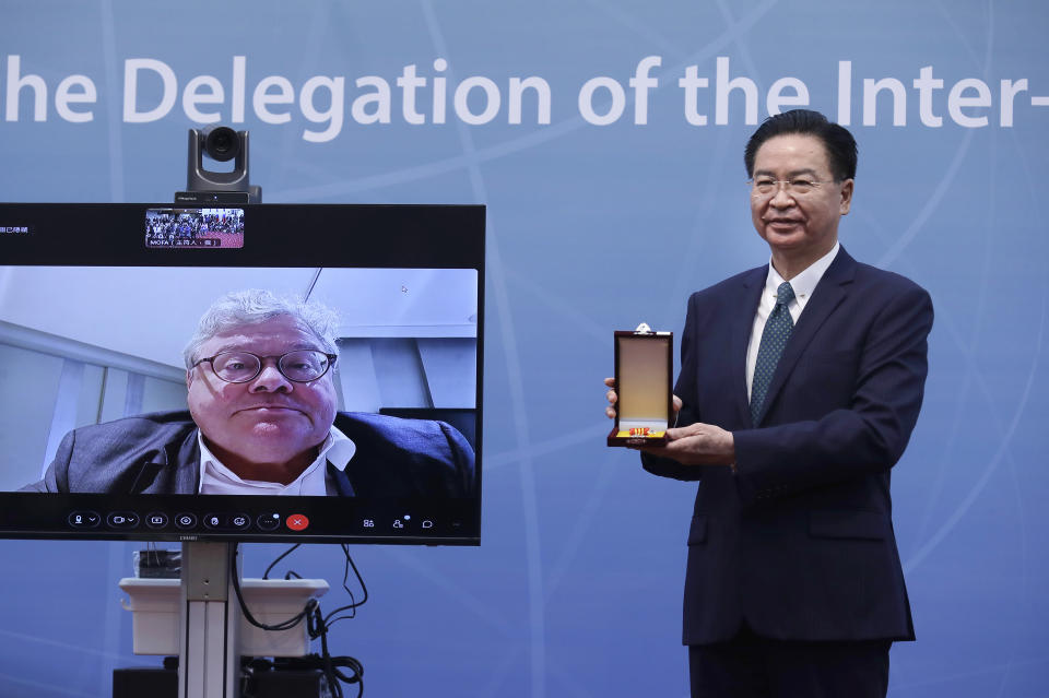 Taiwan Foreign Minister Joseph Wu, right, presents the Special Diplomatic Medal to German Sen. Reinhard Butikofer, a member of the Inter-Parliamentary Alliance on China, via online video at Ministry of Foreign Affairs in Taipei, Taiwan, Thursday, Nov. 3, 2022. (AP Photo/Chiang Ying-ying)