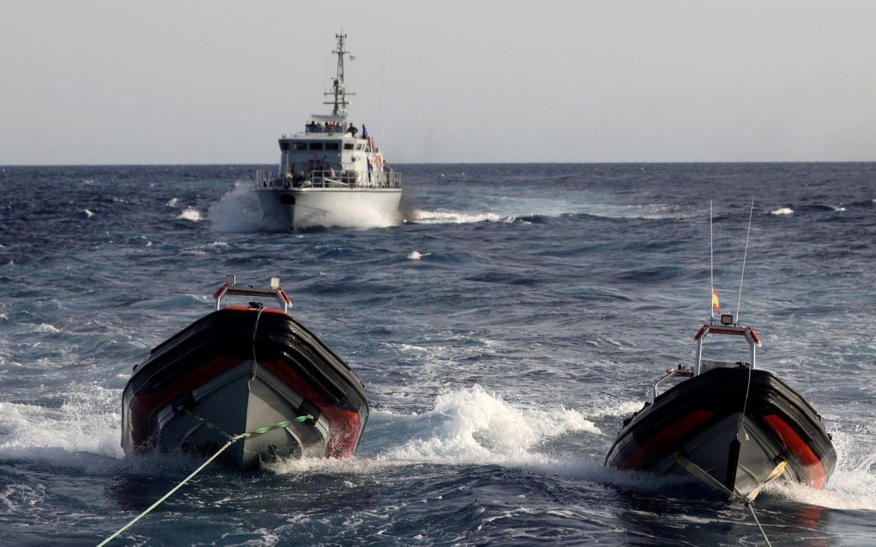 A Libyan coastguard vessel chases away former fishing trawler Golf Azzurro of the Proactiva Open Arms rescue charity in the Western Mediterranean Sea - REUTERS