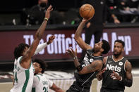 Brooklyn Nets guard Kyrie Irving shoots over Boston Celtics center Robert Williams III during the first half of an NBA basketball game, Thursday, March 11, 2021, in New York. (AP Photo/Adam Hunger)