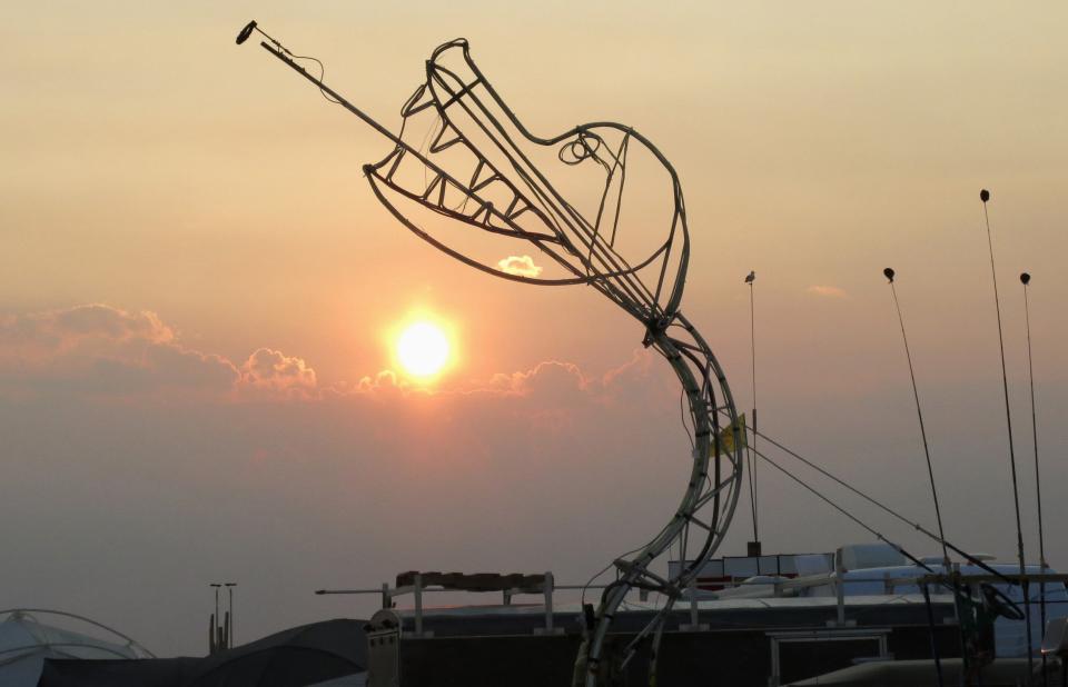 A sculpture of a fire breathing dragon is seen at sunrise during the 2013 Burning Man arts and music festival in the Black Rock Desert of Nevada, August 29, 2013. The federal government issued a permit for 68,000 people from all over the world to gather at the sold out festival, which is celebrating its 27th year, to spend a week in the remote desert cut off from much of the outside world to experience art, music and the unique community that develops. REUTERS/Jim Bourg (UNITED STATES - Tags: SOCIETY) FOR USE WITH BURNING MAN RELATED REPORTING ONLY. FOR EDITORIAL USE ONLY. NOT FOR SALE FOR MARKETING OR ADVERTISING CAMPAIGNS. NO THIRD PARTY SALES. NOT FOR USE BY REUTERS THIRD PARTY DISTRIBUTORS