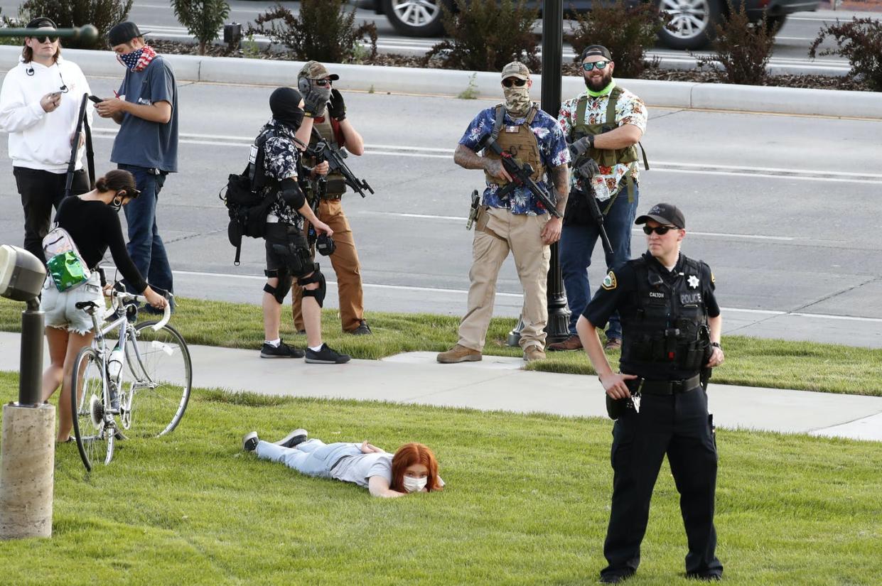 <span class="caption">Armed white citizens and police have historically worked together in the U.S., though it's not clear whether that's what's happening here.</span> <span class="attribution"><a class="link " href="https://www.gettyimages.com/detail/news-photo/armed-counter-protesters-and-a-police-officer-stand-watch-news-photo/1223867050" rel="nofollow noopener" target="_blank" data-ylk="slk:George Frey/Getty Images;elm:context_link;itc:0;sec:content-canvas">George Frey/Getty Images</a></span>