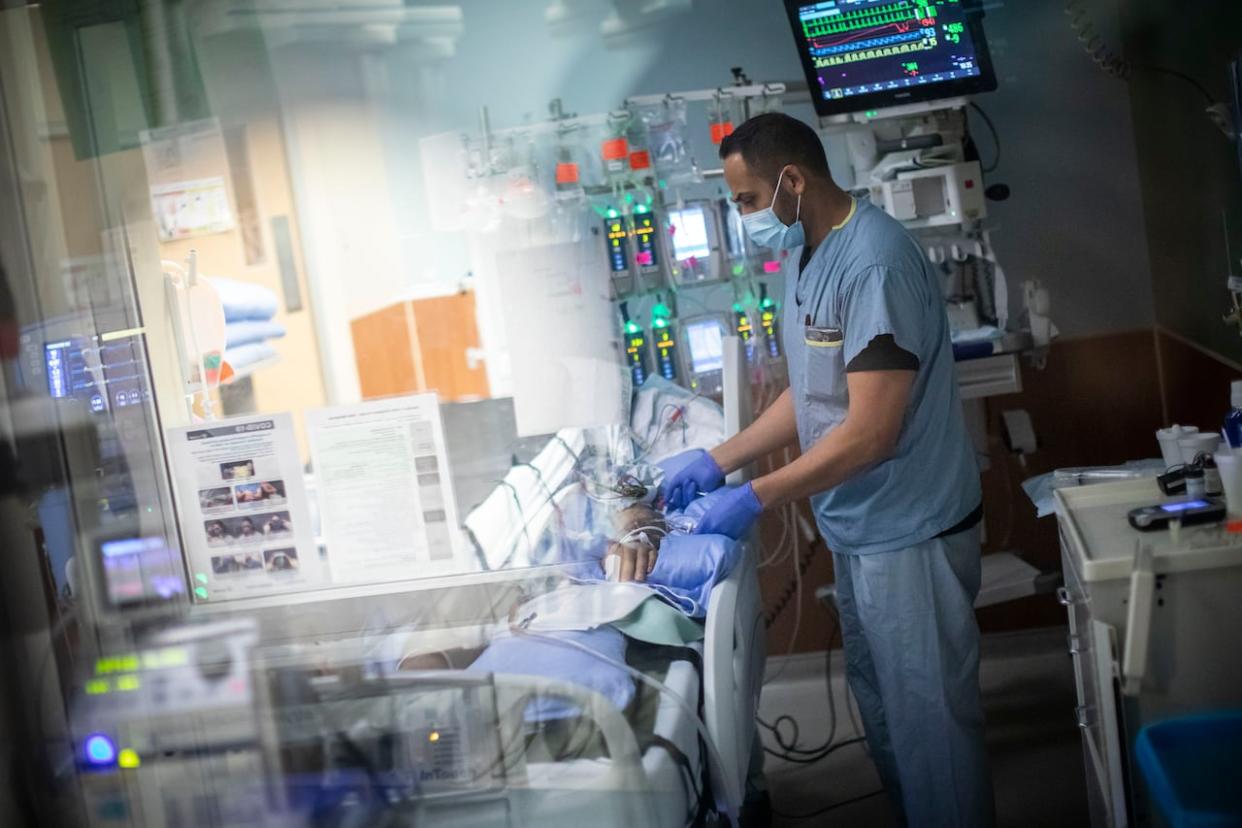 A nurse checks on a patient in the intensive care unit (ICU) at Royal Columbian Hospital in New Westminster, B.C., in this file photo from 2022.  (Ben Nelms/CBC - image credit)