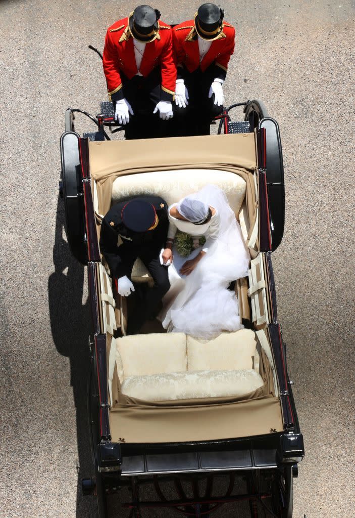 The sweet couple hold each other's hands during their carriage ride through Windsor.