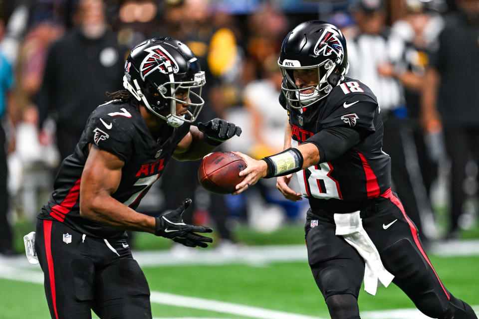 Atlanta quarterback Kirk Cousins ​​​​(18) hands the ball to running back Bijan Robinson (7) 