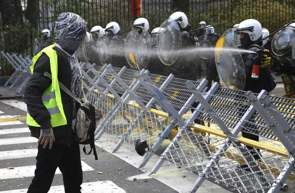 A protestor is sprayed with pepper spray by police during a demonstration in Brussels, Saturday, Dec. 8, 2018. Hundreds of police officers are being mobilized in Brussels Saturday, where yellow vest protesters last week clashed with police and torched two police vehicles. More than 70 people were detained. (AP Photo/Francisco Seco)