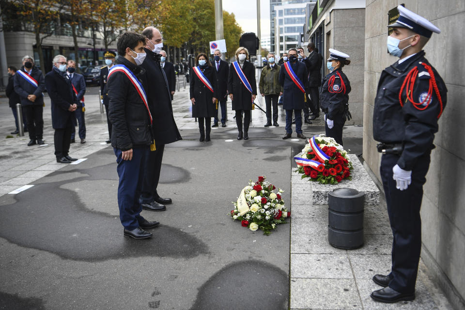 Saint-Denis Mayor Mathieu Hanotin, left, and French Prime Minister Jean Castex participate in a wreath laying ceremony, marking the 5th anniversary of the Nov. 13, 2015 attacks outside the stadium Stade de France in Saint Denis, near Paris, Friday, Nov. 13, 2020. In silence and mourning, France is marking five years since 130 people were killed by Islamic State extremists who targeted the Bataclan concert hall, Paris cafes and the national stadium. (Christophe Archambault/Pool Photo via AP)