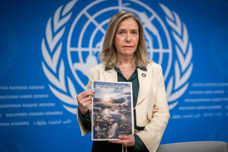 La secrétaire générale de l'OMM, Celeste Saulo, montre le rapport 2023 sur le climat mondial avant une conférence de presse à Genève, le 19 mars 2024 (Fabrice COFFRINI)