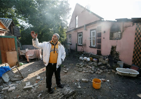 A destroyed house is seen as a local resident stands, near the warehouse storing ammunition for multiple rocket launcher systems at a military base in nearby in Kalynivka, Vinnytsia region, Ukraine September 27, 2017. REUTERS/Gleb Garanich